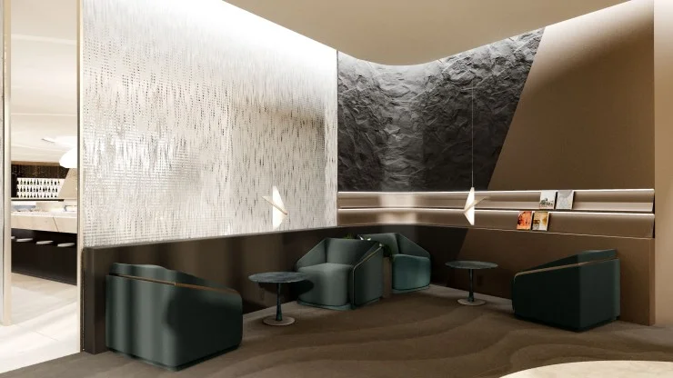 Modern lounge area featuring stylish green armchairs and a chic coffee table against a textured wall with subtle lighting.