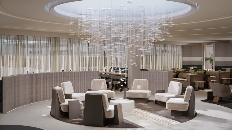 Modern lounge interior featuring a round ceiling installation with suspended art, surrounded by stylish seating and large windows.
