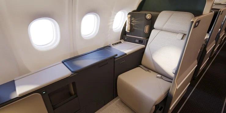 Interior view of a luxurious airplane seat with a window, featuring a modern design and ample legroom.