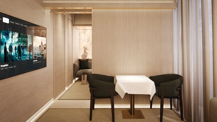 A modern dining area featuring a small table with a white tablecloth, two dark green chairs, and a wall-mounted TV displaying movie options. Light-colored walls with vertical textures and sheer curtains create a warm and inviting atmosphere.