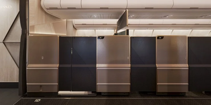 Interior view of a modern airline cabin featuring luxury seating compartments with partitions.