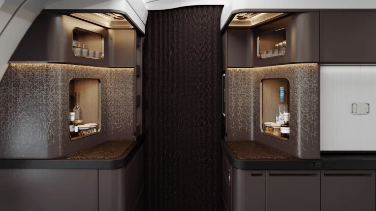 Interior view of an airplane bar area featuring stylish cabinetry, illuminated shelves, and a dark textured wall.