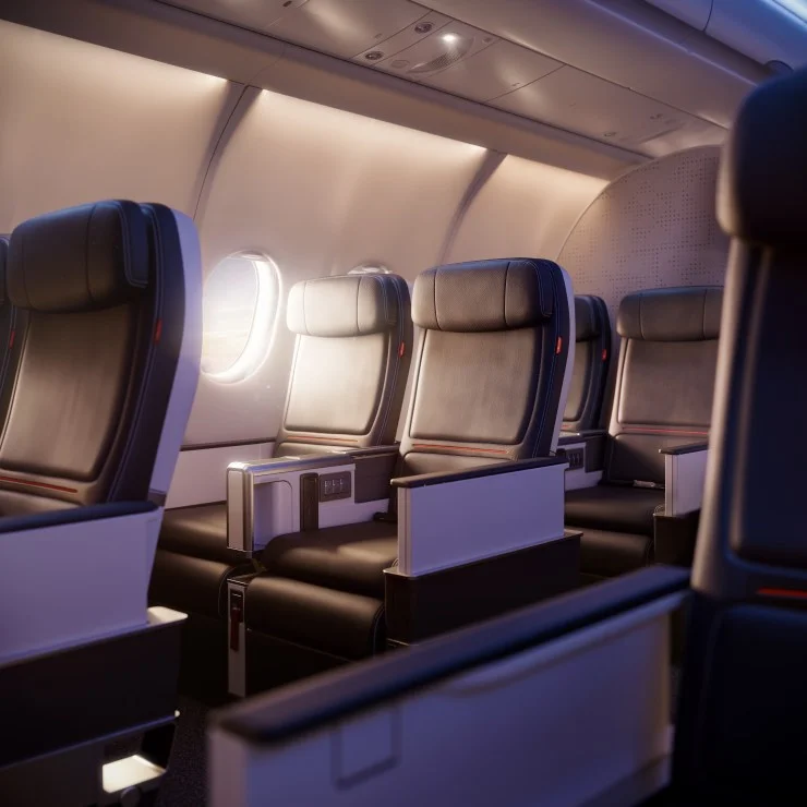 Interior view of an airplane cabin featuring empty, modern leather seats next to a window, with soft ambient lighting.
