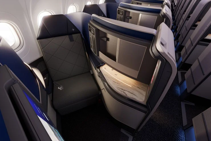 Interior view of an airplane featuring a modern, spacious business class seat with a sleek design and adjustable privacy partition.