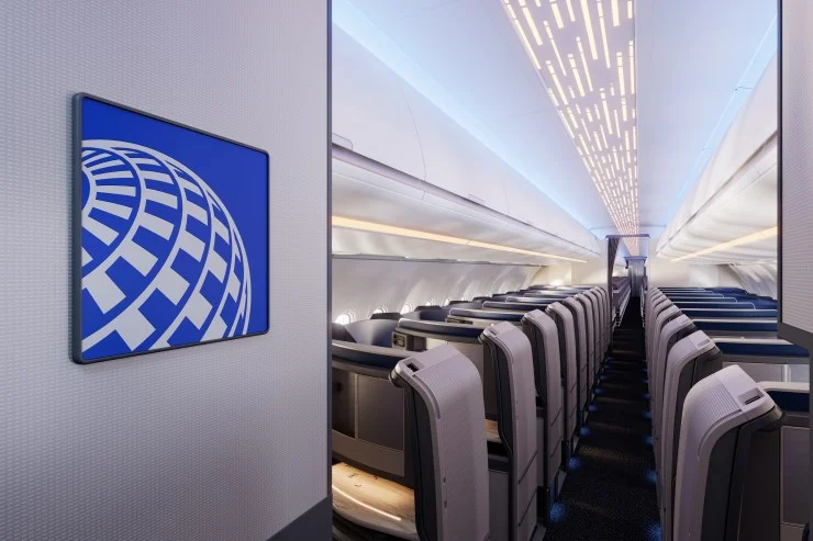 Interior view of an aircraft cabin featuring modern seating and ambient lighting with an airline logo displayed on the wall.