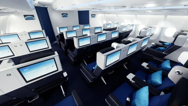 Interior view of an airplane cabin featuring rows of seats with individual screens, stylish blue and white seating, and overhead lighting.