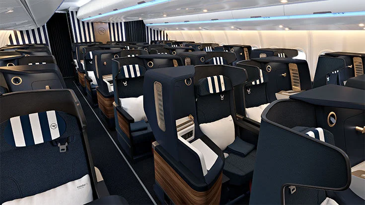 Interior view of an airplane cabin featuring modern seating with dark blue upholstery and striped headrests, designed for passenger comfort.