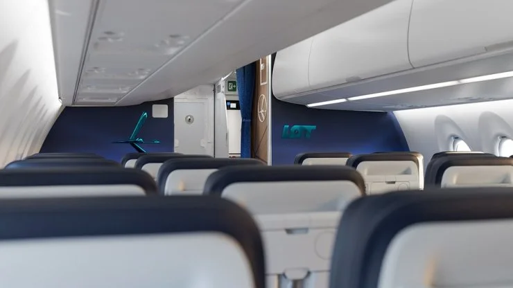 Interior view of a LOT Polish Airlines cabin, featuring modern seating and design elements.