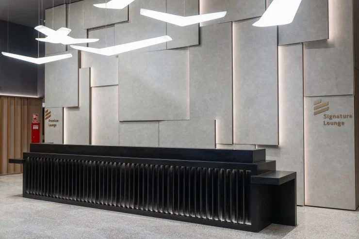 Interior view of the LATAM Signature Lounge featuring a modern check-in desk and contemporary wall design.
