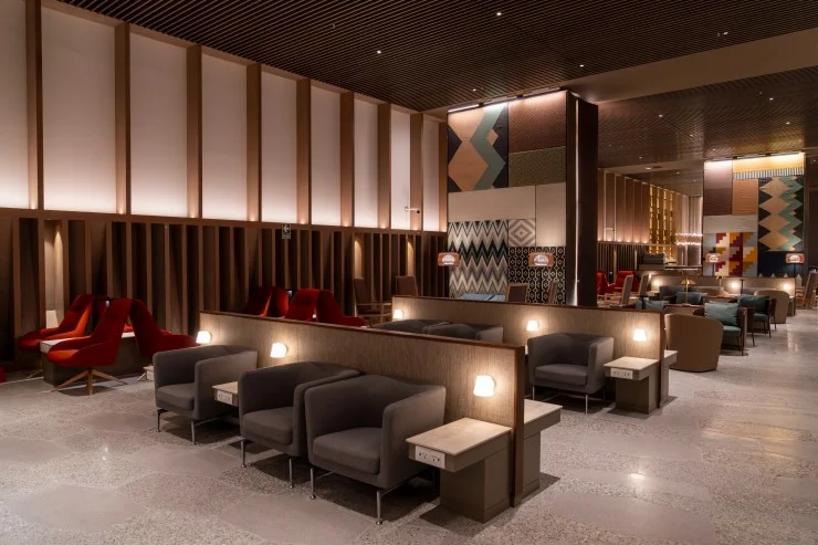 Interior view of the LATAM Lounge at Jorge Chávez International Airport, featuring a mix of modern seating arrangements, contemporary decor, and ambient lighting.