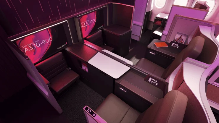 Interior view of Virgin Atlantic's A330-900 business class cabin featuring individual seats with privacy screens and modern design elements.