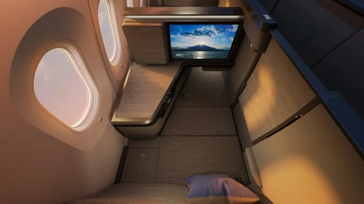 Interior view of ANA's new business class suite, THE Room FX, featuring a large high-definition TV, spacious side console, and cabin design emphasizing comfort and privacy.